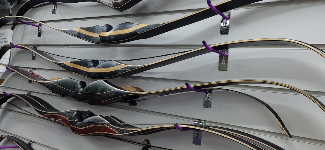 A selection of Recurve wooden one piece bows as displayed in the shop at Indigo Archery
